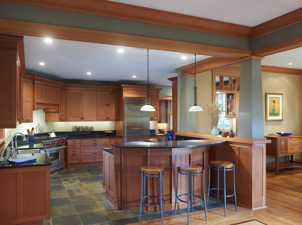 Design ideas for a large arts and crafts u-shaped eat-in kitchen in DC Metro with shaker cabinets, stainless steel appliances, a farmhouse sink, dark wood cabinets, quartz benchtops, slate floors and a peninsula.