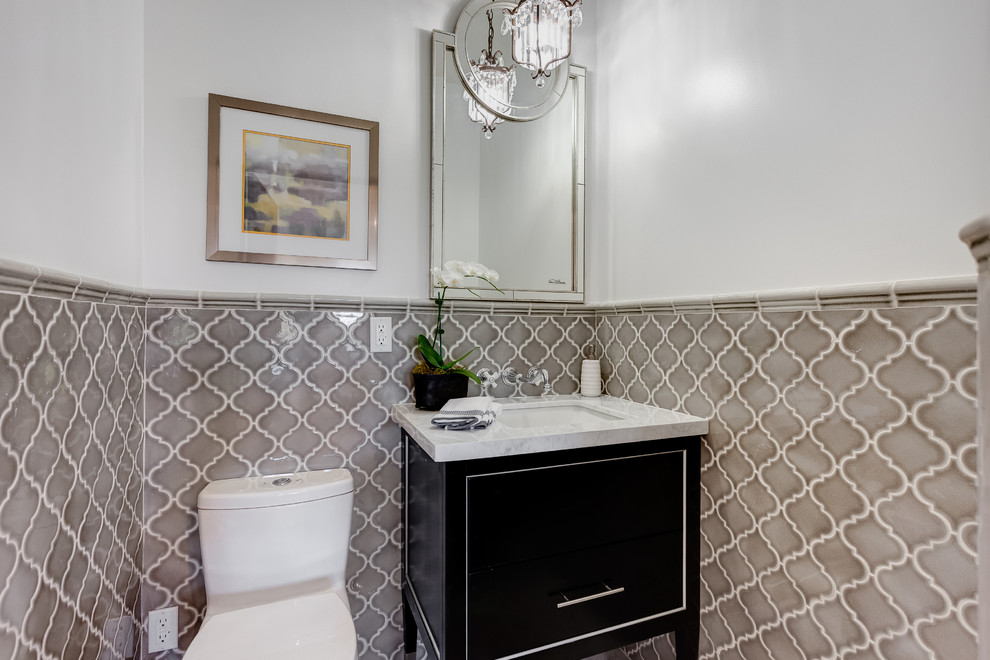 Design ideas for a mid-sized mediterranean powder room in Los Angeles with flat-panel cabinets, dark wood cabinets, a one-piece toilet, brown tile, ceramic tile, white walls, granite benchtops and white benchtops.