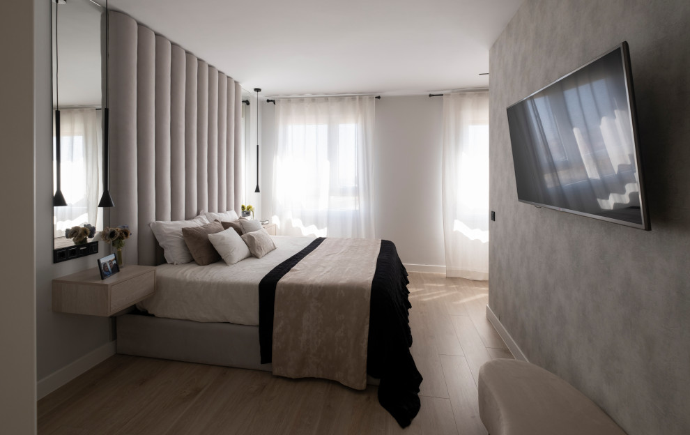 Ejemplo de dormitorio principal minimalista grande con paredes grises, suelo laminado, suelo beige y papel pintado