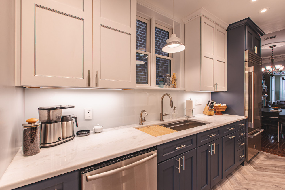 Photo of a small traditional galley kitchen in DC Metro with an undermount sink, recessed-panel cabinets, white cabinets, marble benchtops, white splashback, subway tile splashback, stainless steel appliances, porcelain floors, grey floor and grey benchtop.
