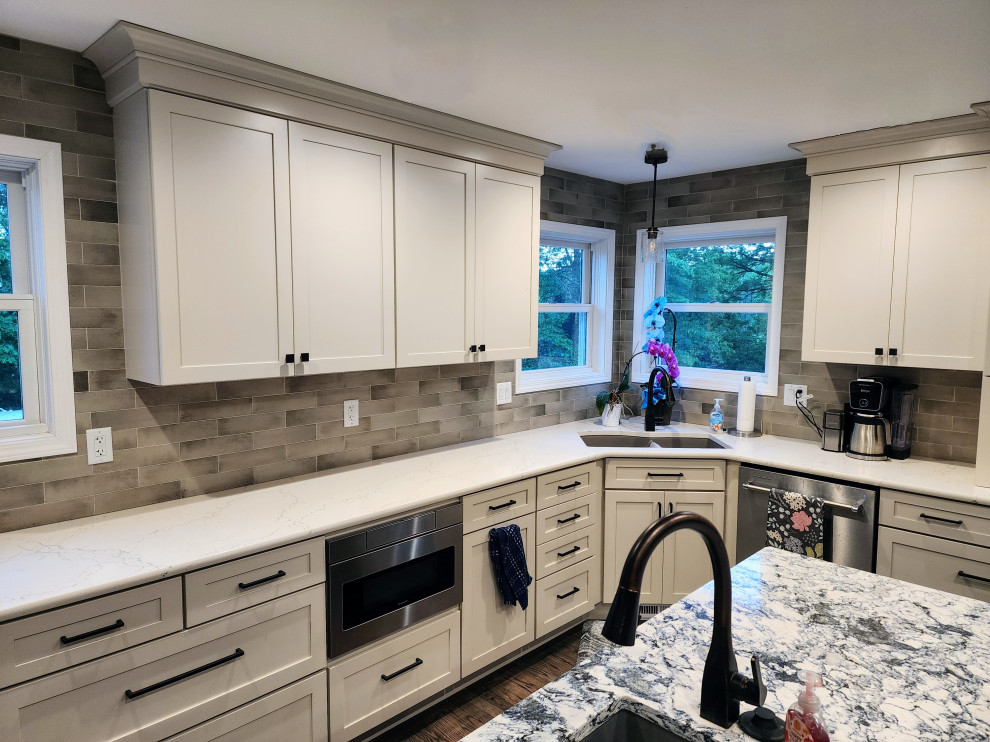 Eat-in kitchen - large cottage l-shaped medium tone wood floor and gray floor eat-in kitchen idea with an undermount sink, shaker cabinets, subway tile backsplash, stainless steel appliances, an island and multicolored countertops