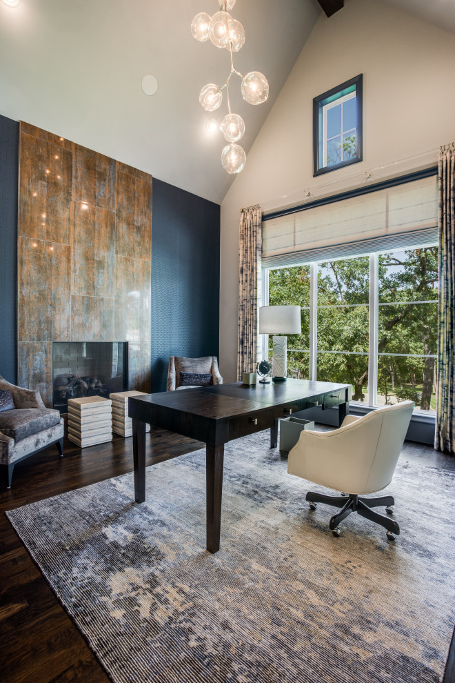 This is an example of a large transitional study room in Dallas with blue walls, medium hardwood floors, a standard fireplace, a tile fireplace surround, a freestanding desk, brown floor, vaulted and wallpaper.