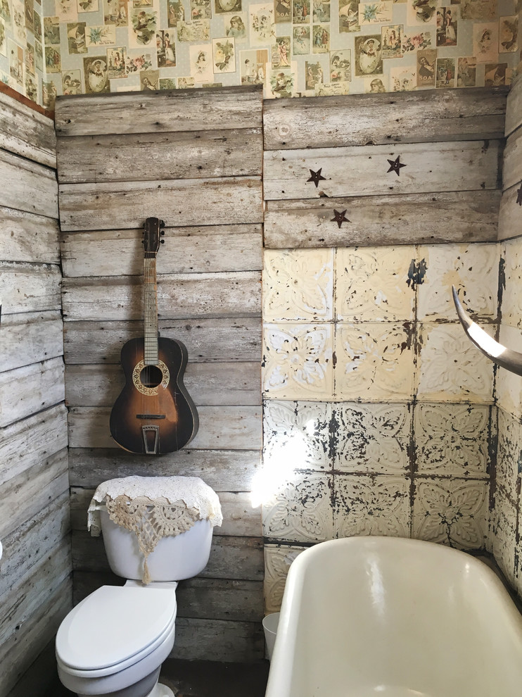 Small country bathroom in Other with raised-panel cabinets, distressed cabinets, a claw-foot tub, a two-piece toilet, beige tile, metal tile, brown walls, linoleum floors and an integrated sink.