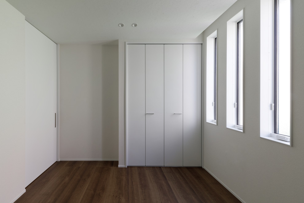 Foto di una piccola camera matrimoniale moderna con pareti bianche, pavimento in legno verniciato, pavimento marrone, soffitto in carta da parati e carta da parati