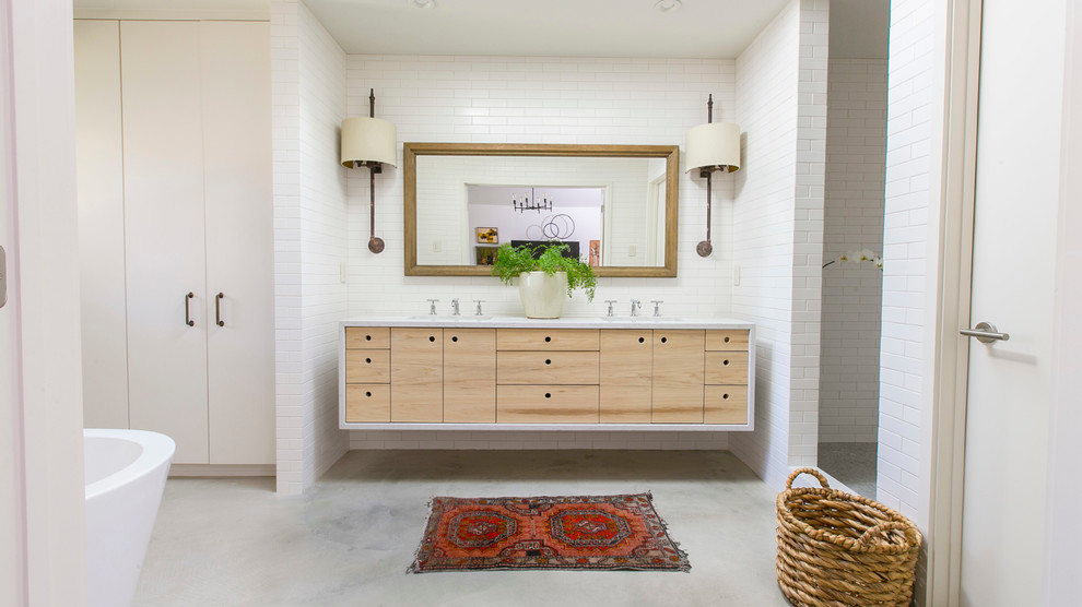 This is an example of a modern bathroom in Austin with an undermount sink, flat-panel cabinets, light wood cabinets, a freestanding tub, an open shower, white tile, subway tile and an open shower.