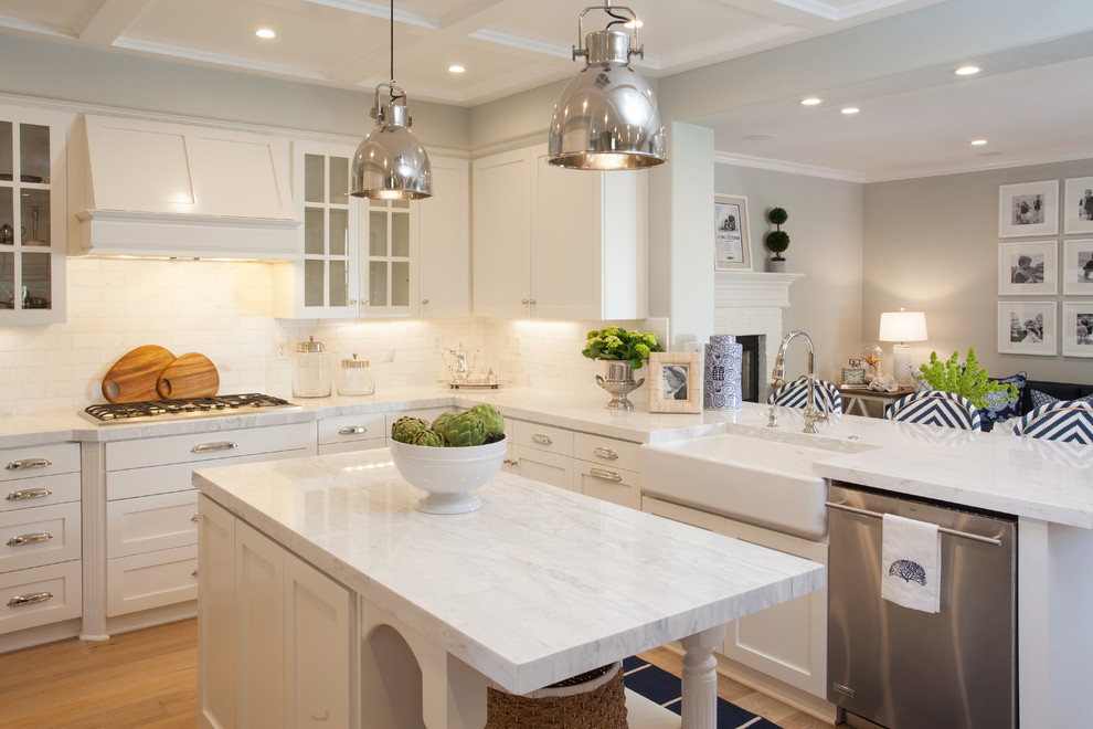 Transitional l-shaped kitchen in San Diego with a farmhouse sink, shaker cabinets, white cabinets, white splashback, subway tile splashback, stainless steel appliances, medium hardwood floors and with island.