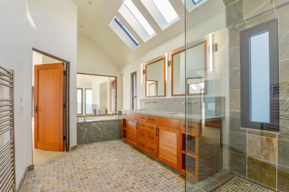 Inspiration for a large contemporary master bathroom in Orange County with furniture-like cabinets, medium wood cabinets, an undermount tub, a corner shower, gray tile, slate, white walls, slate floors, an undermount sink, soapstone benchtops, grey floor and a hinged shower door.