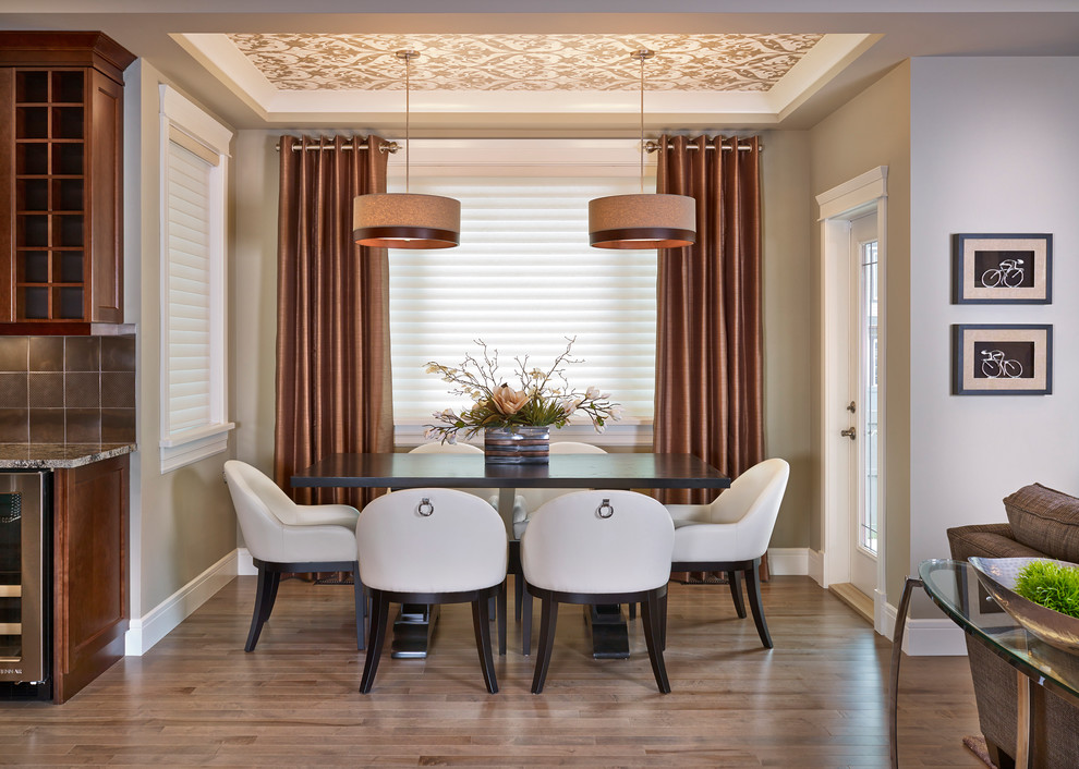 This is an example of a transitional dining room in Edmonton with beige walls and dark hardwood floors.