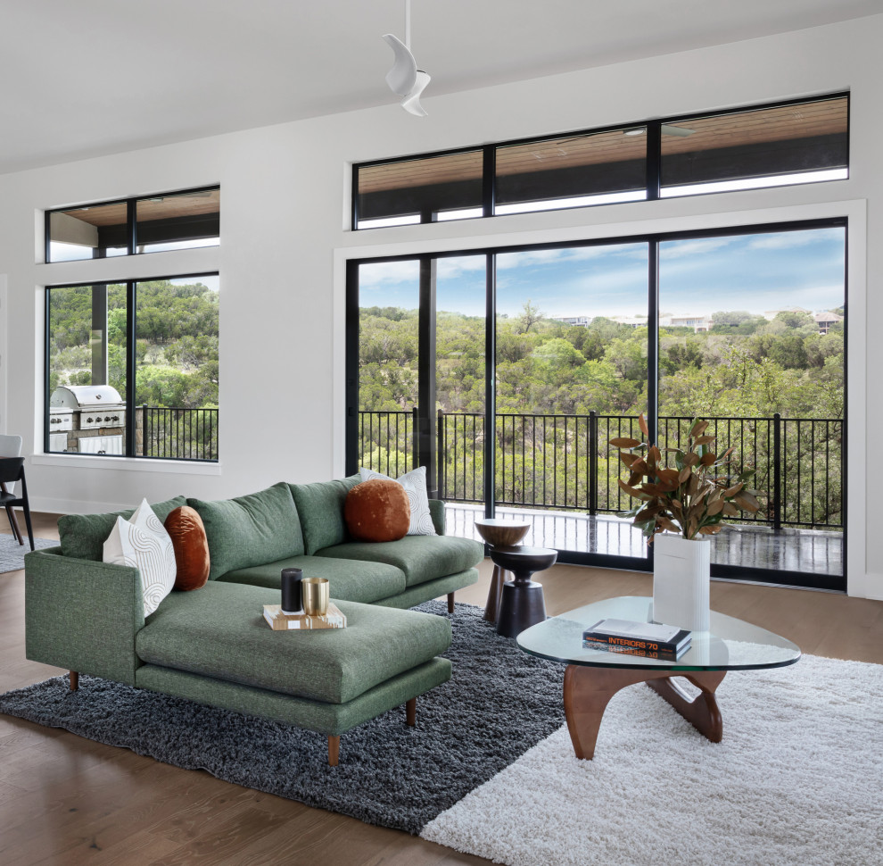 Großes, Fernseherloses, Offenes Modernes Wohnzimmer mit weißer Wandfarbe, braunem Holzboden und braunem Boden in Austin