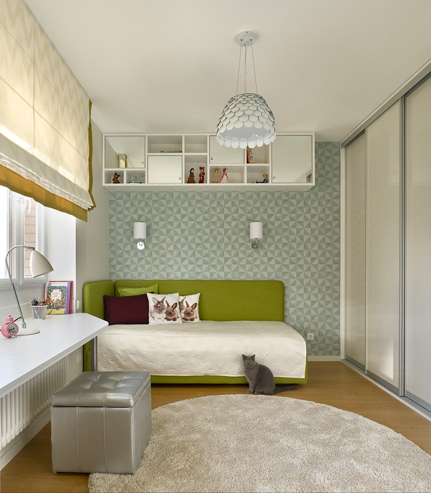 Photo of a contemporary kids' bedroom for girls in Moscow with medium hardwood floors.