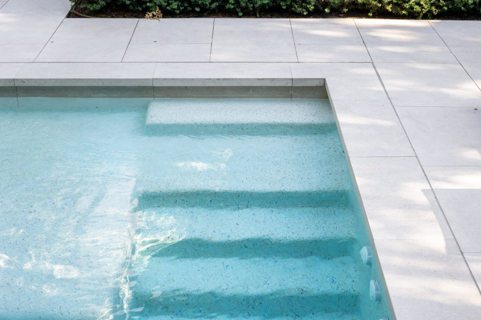 Идея дизайна: маленький прямоугольный ландшафтный бассейн на боковом дворе в стиле неоклассика (современная классика) с покрытием из каменной брусчатки для на участке и в саду