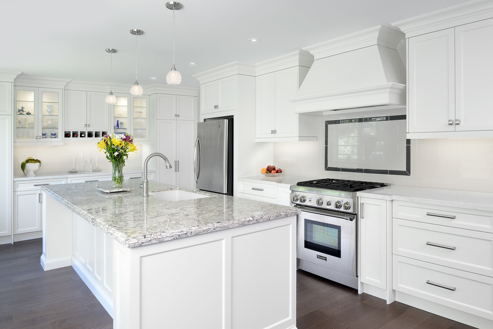 Example of a mid-sized transitional l-shaped medium tone wood floor and brown floor eat-in kitchen design in Toronto with an undermount sink, shaker cabinets, white cabinets, quartz countertops, white backsplash, subway tile backsplash, stainless steel appliances and an island