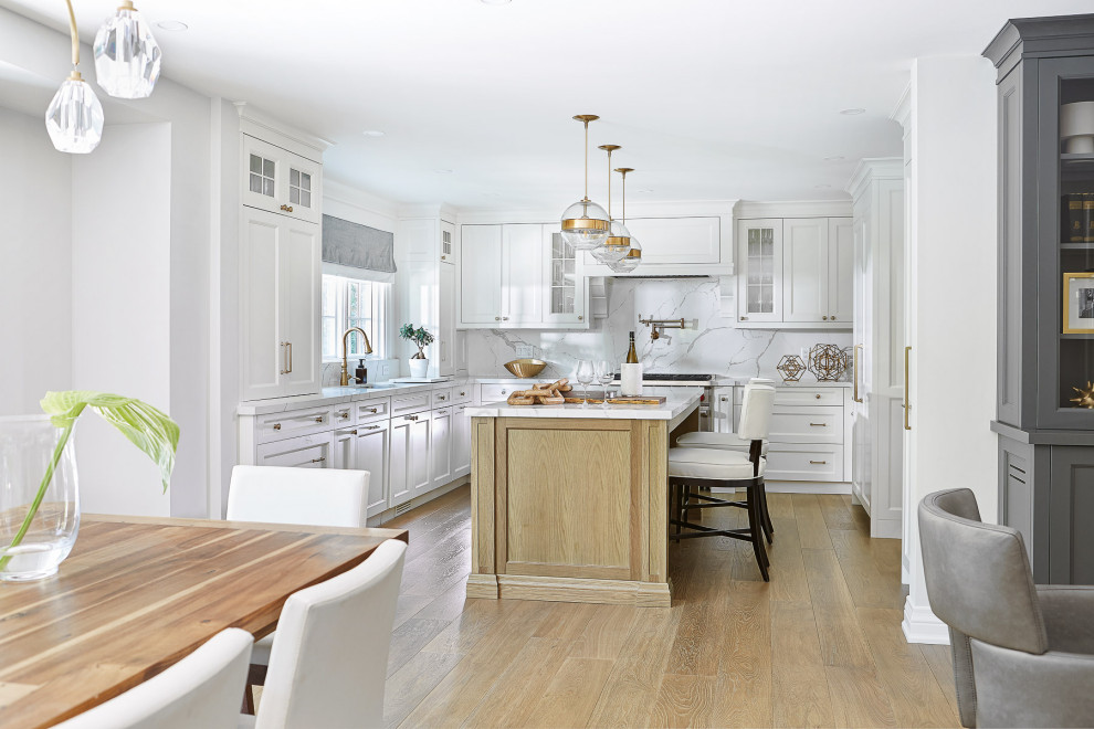 Example of a large transitional u-shaped light wood floor open concept kitchen design in Toronto with an undermount sink, recessed-panel cabinets, white cabinets, white backsplash, an island and white countertops