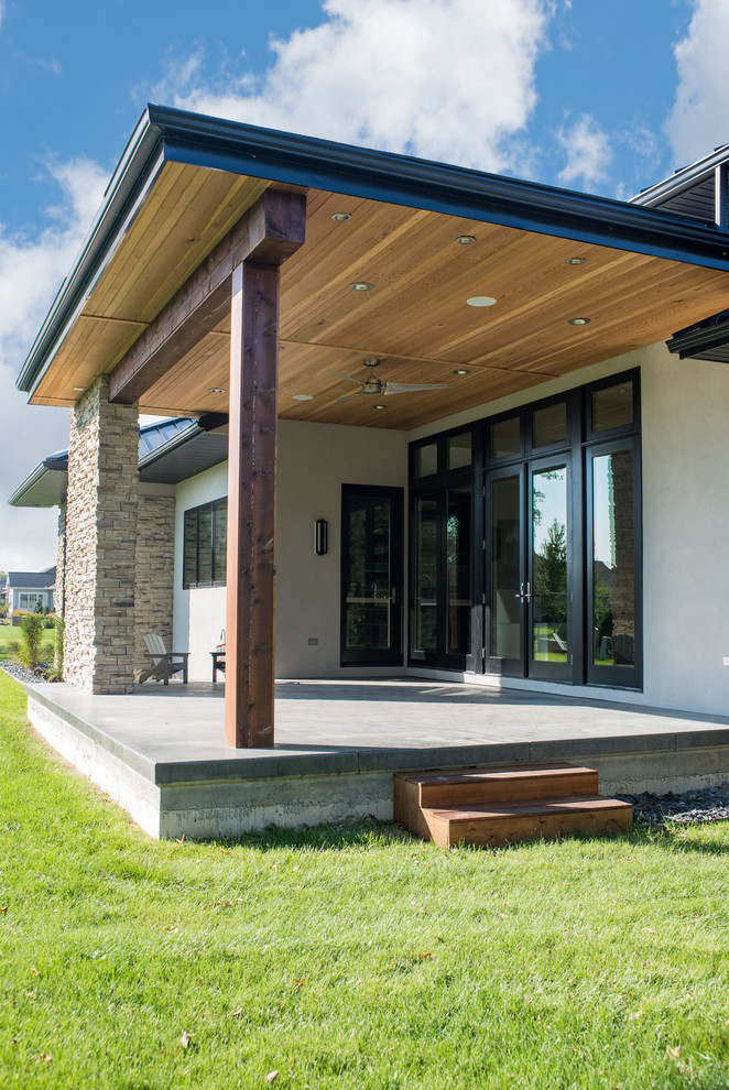 Mid-sized minimalist beige two-story stucco house exterior photo with a hip roof and a metal roof