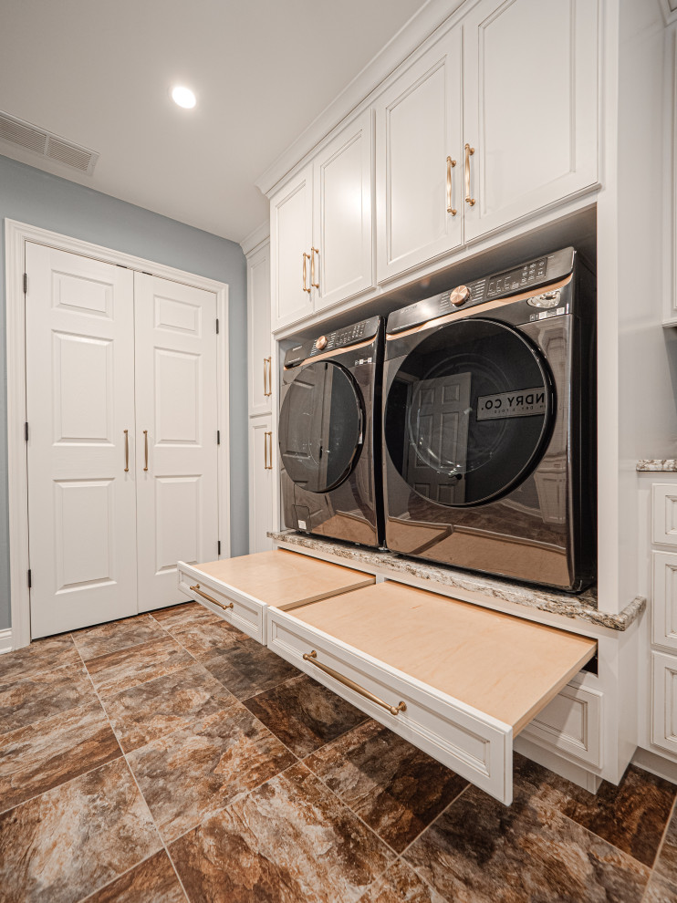 This is an example of a mid-sized beach style u-shaped dedicated laundry room in Other with an undermount sink, flat-panel cabinets, white cabinets, granite benchtops, blue walls, vinyl floors, an integrated washer and dryer, multi-coloured floor and multi-coloured benchtop.