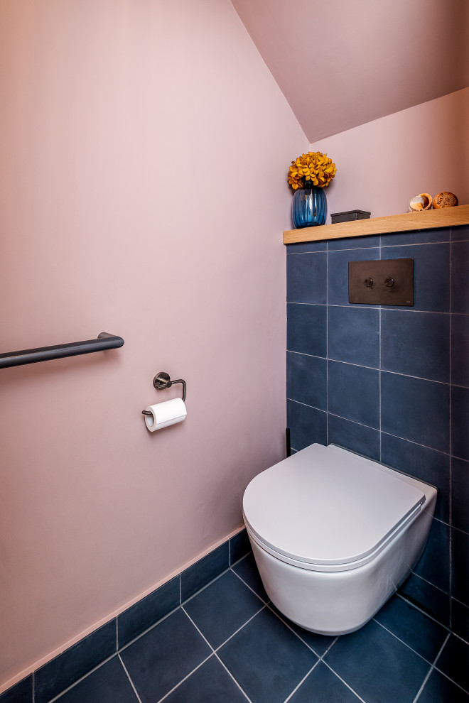 Kleine Moderne Gästetoilette mit Wandtoilette, blauen Fliesen, Porzellanfliesen, rosa Wandfarbe, Porzellan-Bodenfliesen, Wandwaschbecken und blauem Boden in London