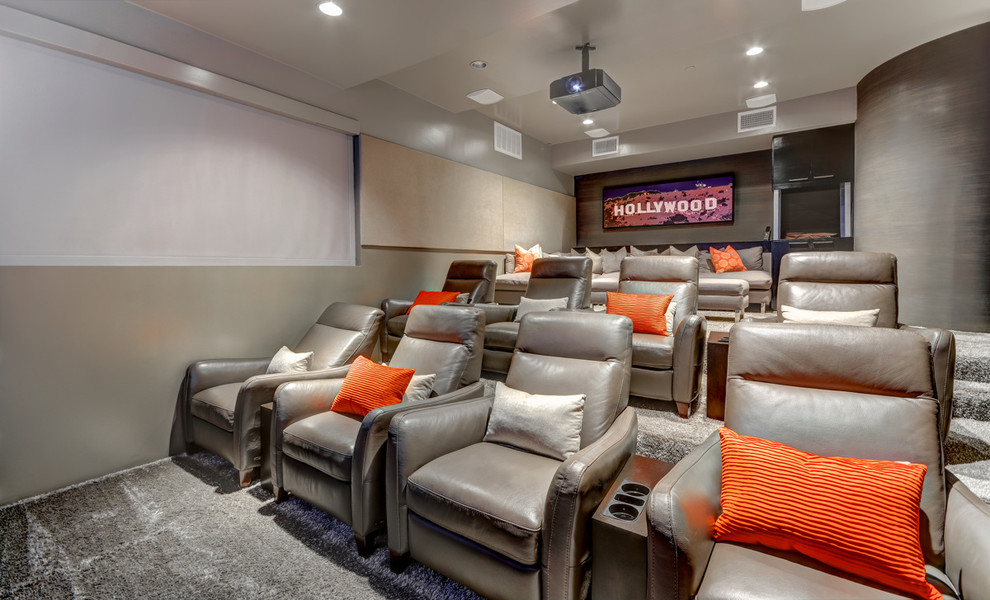 Inspiration for a large modern enclosed home theatre in Orange County with grey walls, carpet, a projector screen and grey floor.