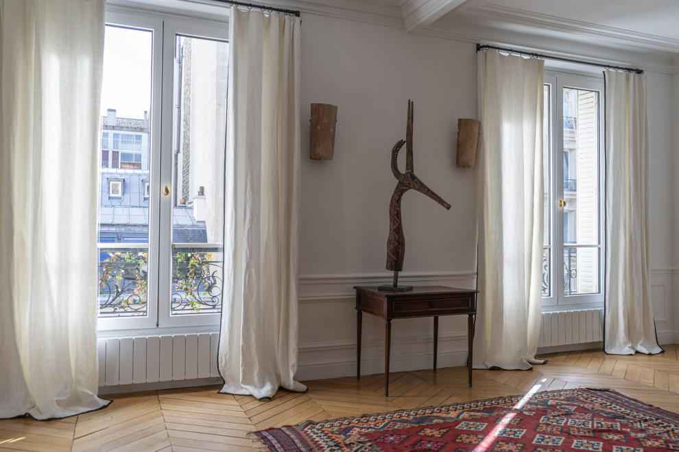 This is an example of a contemporary living room in Paris with white walls and no tv.