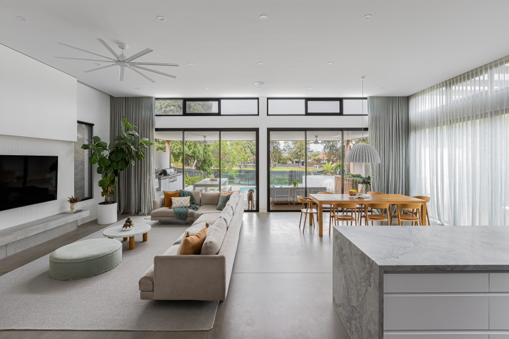 Modernes Wohnzimmer ohne Kamin mit weißer Wandfarbe, Betonboden, TV-Wand und grauem Boden in Melbourne