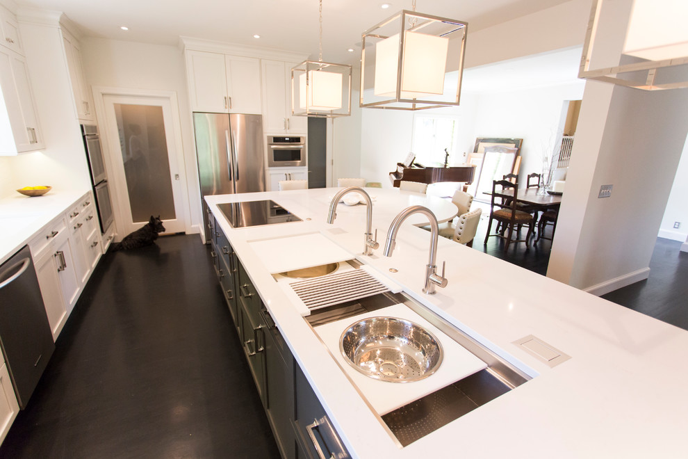 Example of a large transitional l-shaped dark wood floor and brown floor kitchen design with an undermount sink, shaker cabinets, white cabinets, quartz countertops, white backsplash, stainless steel appliances, an island and white countertops