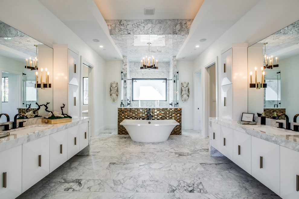 This is an example of a large mediterranean master bathroom in Dallas with flat-panel cabinets, white cabinets, a freestanding tub, a double shower, marble, white walls, marble floors, marble benchtops, a hinged shower door, gray tile, an undermount sink, grey floor and grey benchtops.