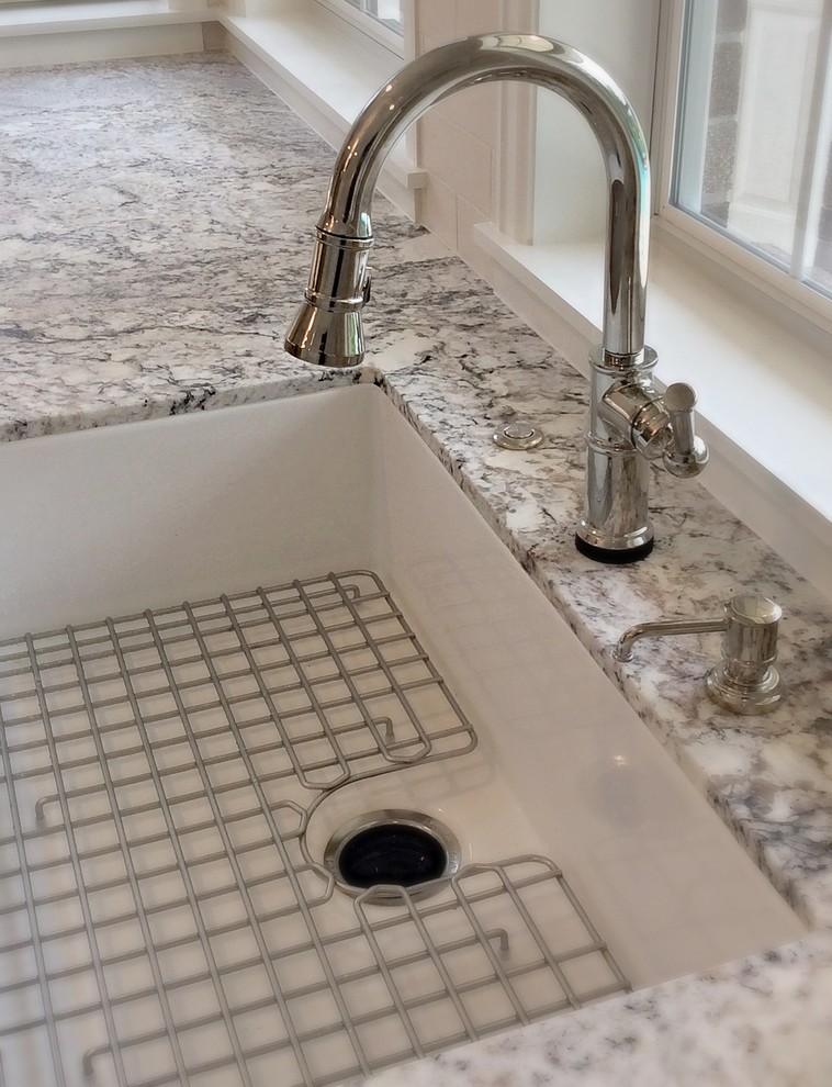 Eat-in kitchen - mid-sized transitional u-shaped ceramic tile eat-in kitchen idea in Houston with a farmhouse sink, recessed-panel cabinets, white cabinets, granite countertops, white backsplash, stone tile backsplash, stainless steel appliances and an island