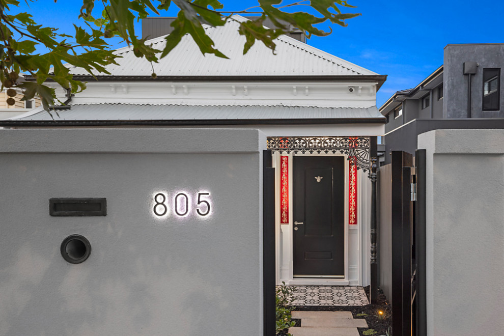 Photo of a mid-sized contemporary two-storey white house exterior in Melbourne with wood siding, a gable roof and a metal roof.