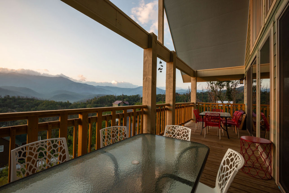 Inspiration for a mid-sized rustic backyard deck remodel with a roof extension