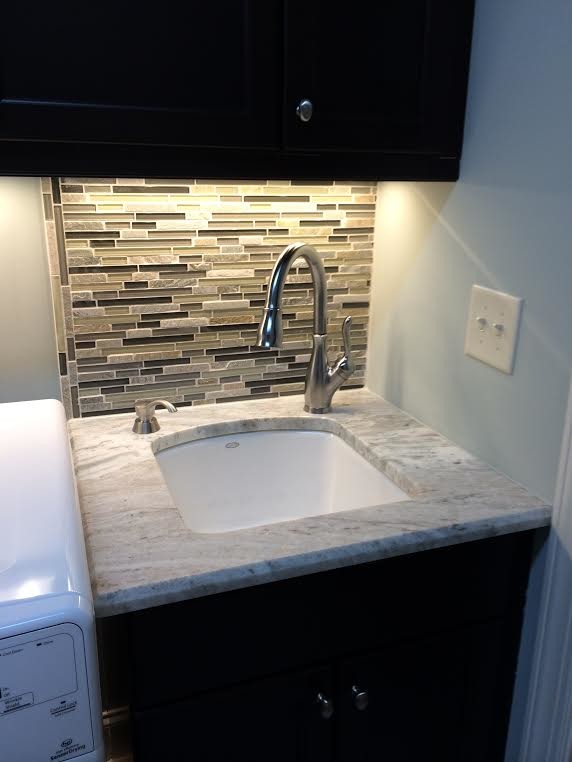 Design ideas for a small contemporary single-wall laundry room in Raleigh with an utility sink and marble benchtops.