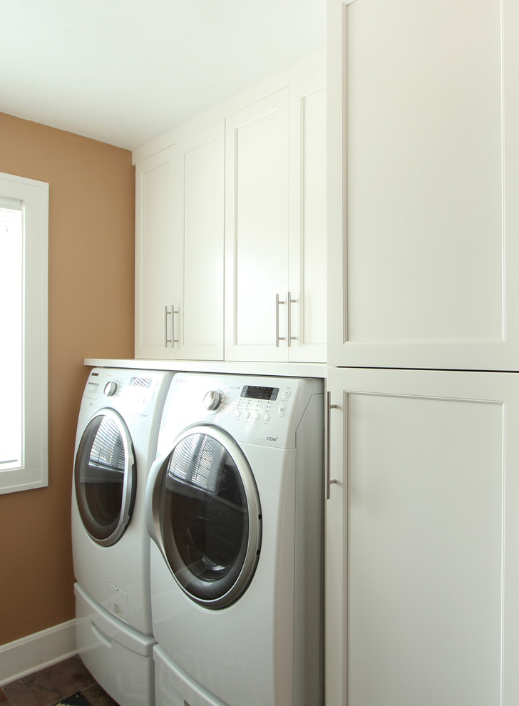 Inspiration for a small transitional galley dedicated laundry room in Other with recessed-panel cabinets, white cabinets, laminate benchtops, beige walls, slate floors, a side-by-side washer and dryer and multi-coloured floor.