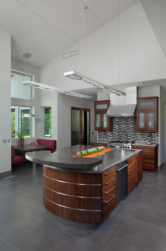 Inspiration for a large contemporary l-shaped open plan kitchen in Grand Rapids with a double-bowl sink, flat-panel cabinets, dark wood cabinets, stainless steel benchtops, white splashback, stainless steel appliances, ceramic floors and with island.