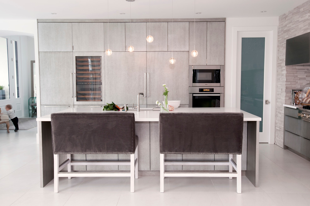 Design ideas for a contemporary kitchen in Vancouver with flat-panel cabinets, grey cabinets, grey splashback, stone tile splashback and panelled appliances.