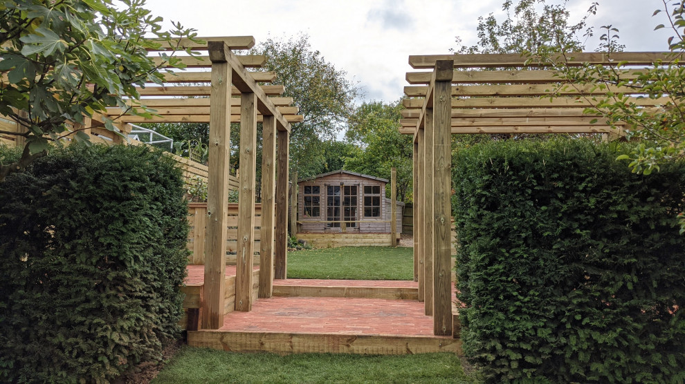 Cette image montre un jardin arrière design de taille moyenne et l'été avec des solutions pour vis-à-vis, une exposition partiellement ombragée, des pavés en brique et une clôture en bois.