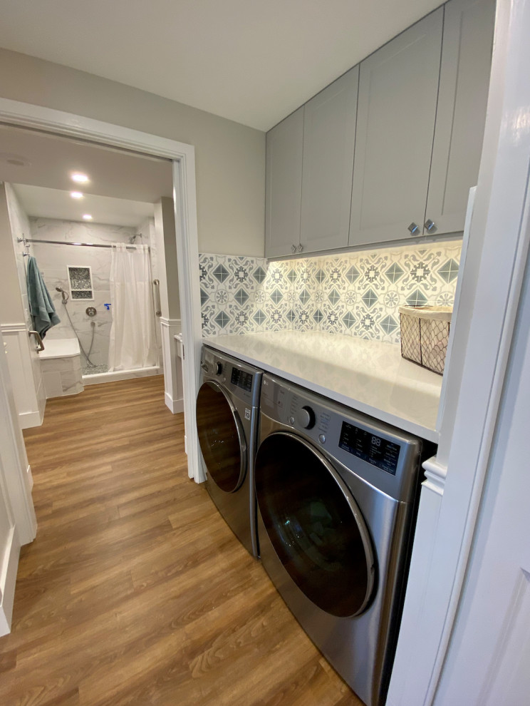This is an example of a medium sized classic single-wall utility room in Philadelphia with shaker cabinets, grey cabinets, engineered stone countertops, multi-coloured splashback, terracotta splashback, multi-coloured walls, vinyl flooring, a side by side washer and dryer, brown floors and white worktops.