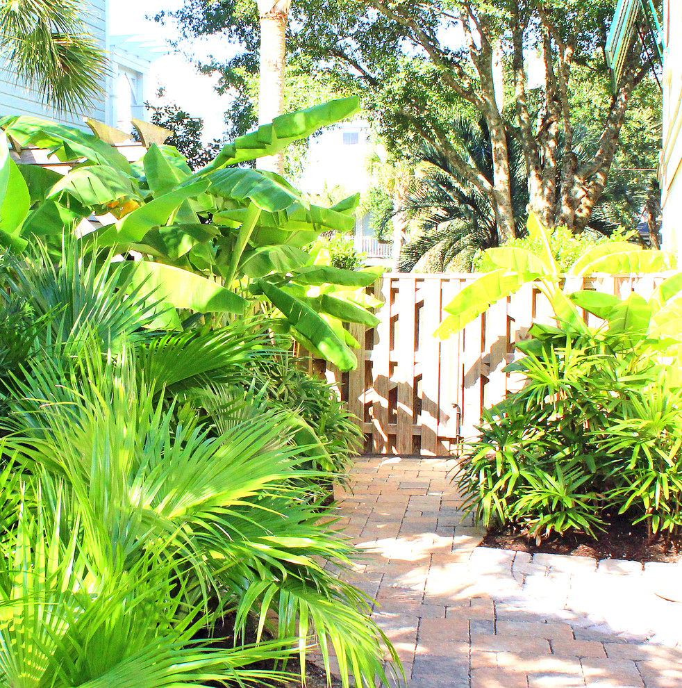 This is an example of a beach style partial sun garden in Charleston with brick pavers.