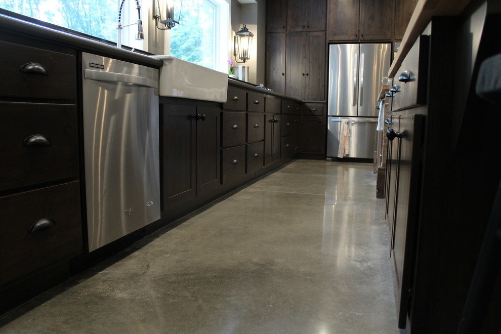 This is an example of a mid-sized contemporary eat-in kitchen in Other with a farmhouse sink, stainless steel appliances, concrete floors and with island.