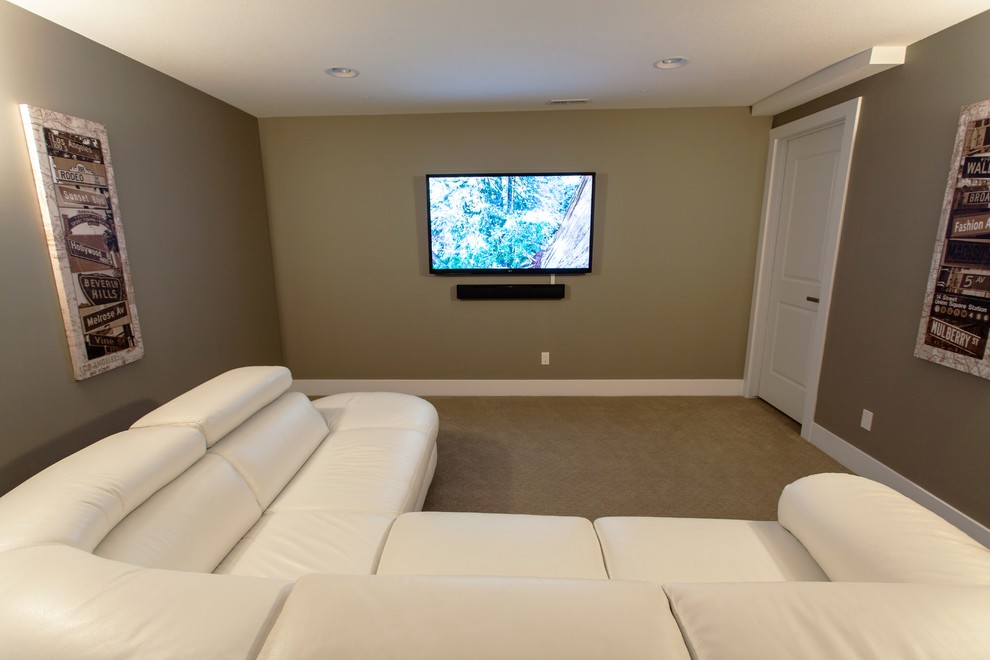 This is an example of a mid-sized contemporary enclosed home theatre in Calgary with brown walls, carpet and a wall-mounted tv.