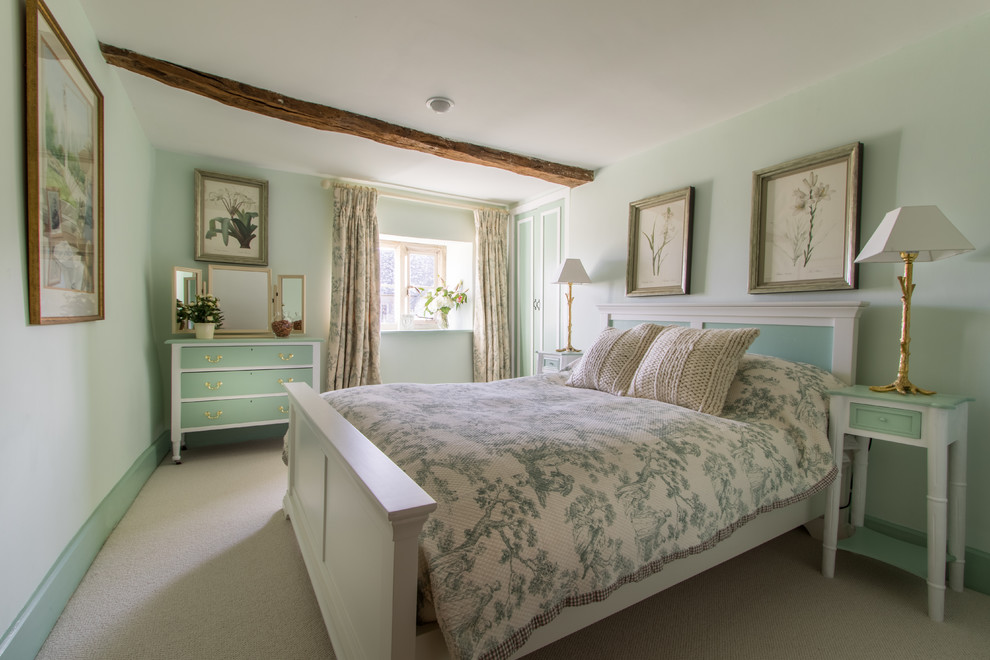 This is an example of a country guest bedroom in London with green walls, carpet and no fireplace.