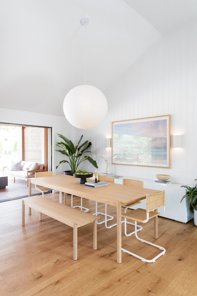 Esempio di una sala da pranzo costiera con pareti bianche, pavimento in legno massello medio, pavimento marrone e soffitto a volta