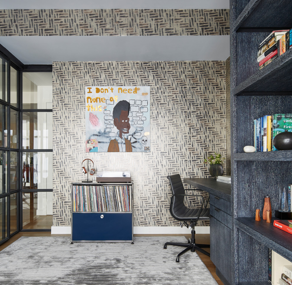 Design ideas for a mid-sized contemporary home office in New York with a library, multi-coloured walls, a built-in desk and wallpaper.