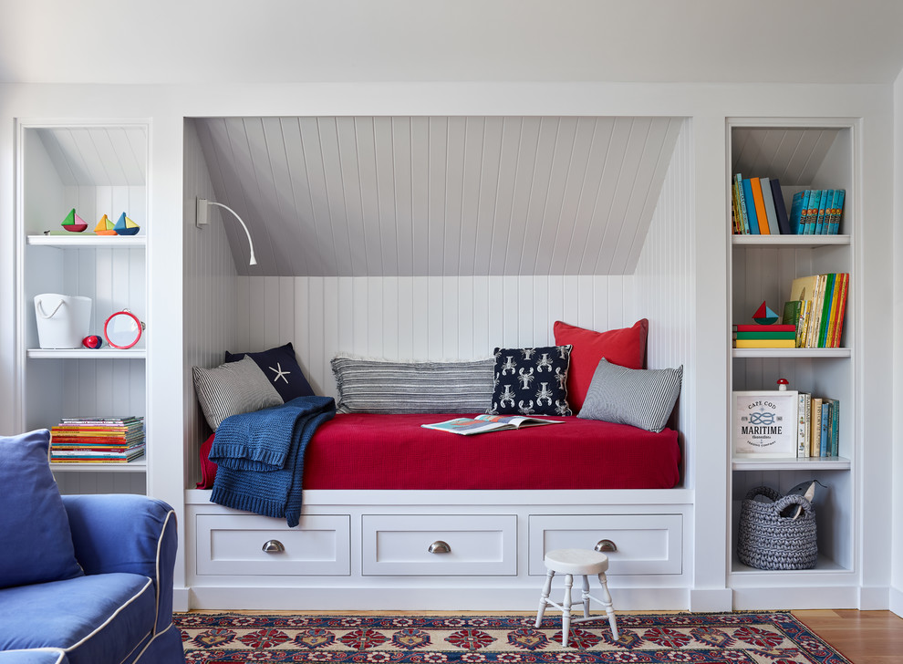 This is an example of a beach style gender-neutral kids' bedroom in Boston with white walls, medium hardwood floors and brown floor.