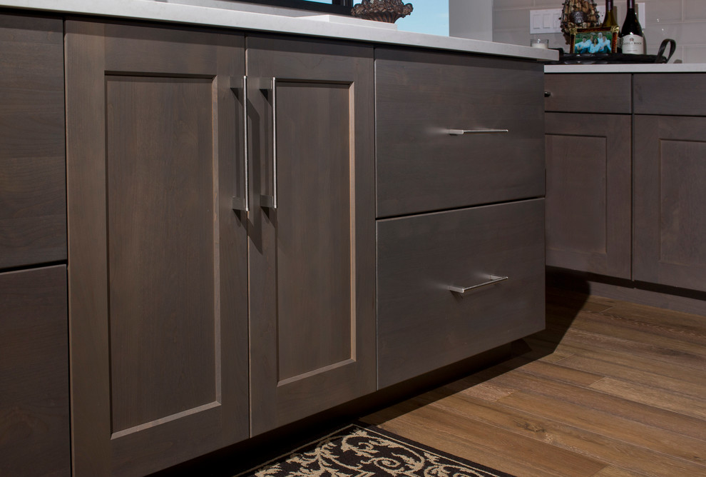 Example of a large transitional u-shaped medium tone wood floor eat-in kitchen design in Denver with an undermount sink, recessed-panel cabinets, gray cabinets, quartz countertops, white backsplash, ceramic backsplash, stainless steel appliances and two islands