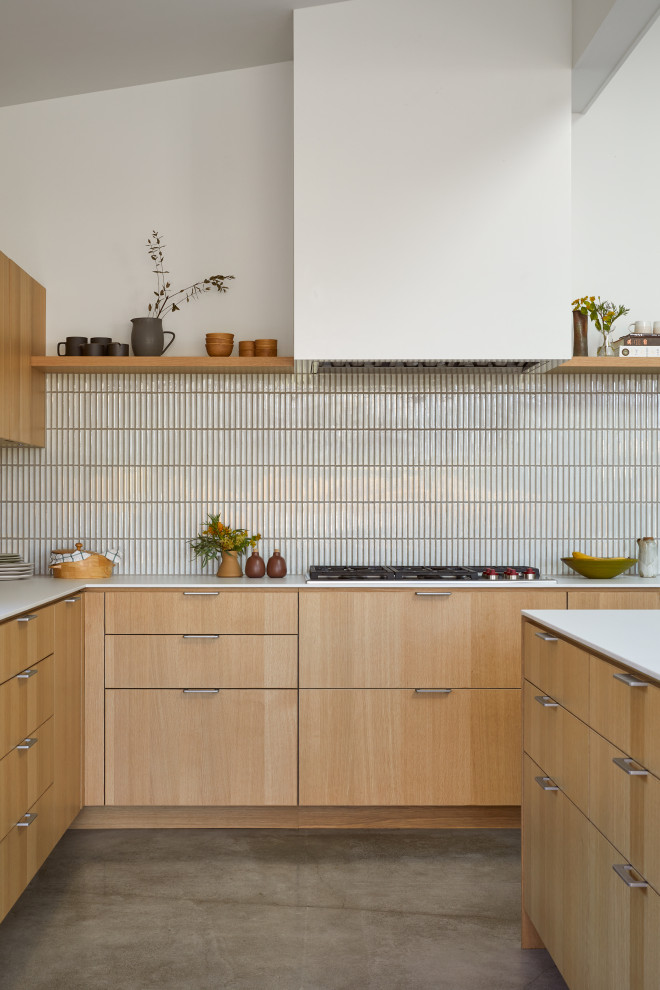 Inspiration for a large modern l-shaped open plan kitchen in San Francisco with an undermount sink, flat-panel cabinets, light wood cabinets, white splashback, ceramic splashback, stainless steel appliances, concrete floors, with island, grey floor, white benchtop and exposed beam.