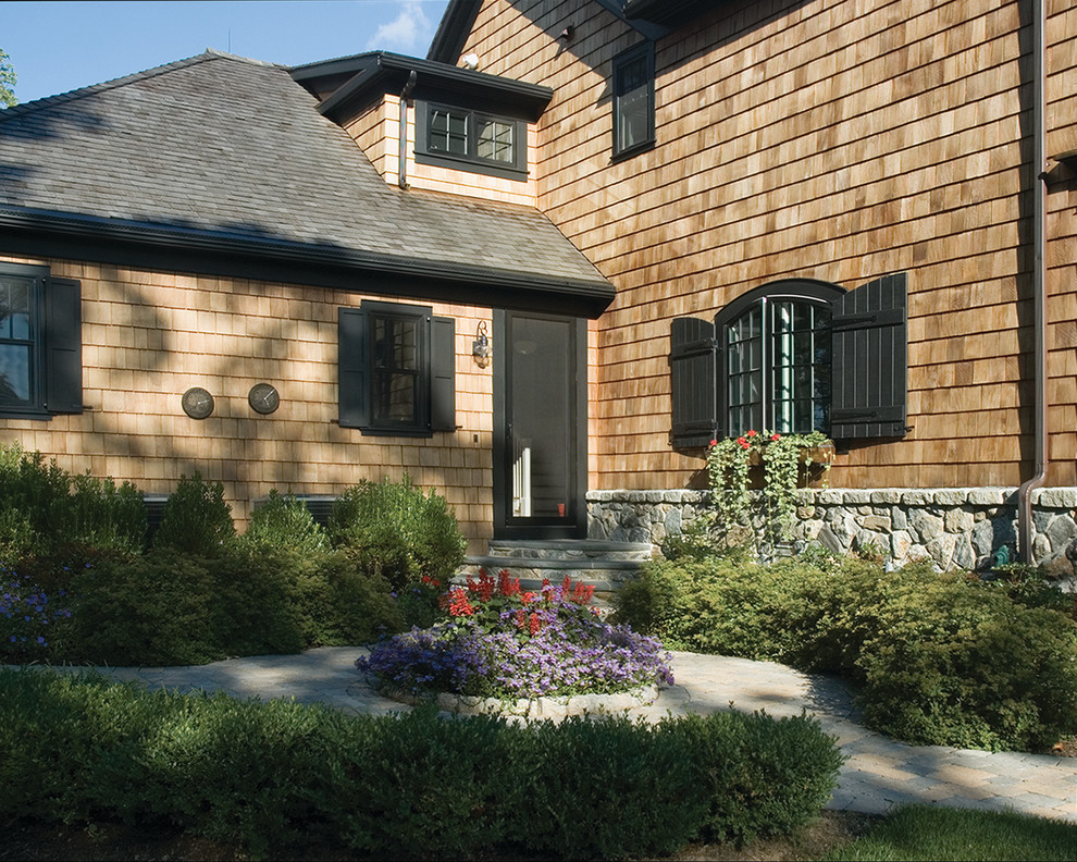 Inspiration for a mid-sized arts and crafts two-storey house exterior in New York with wood siding, a hip roof and a shingle roof.