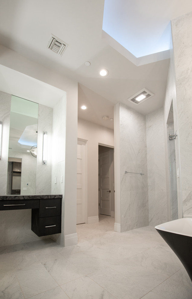 Inspiration för stora moderna flerfärgat en-suite badrum, med släta luckor, svarta skåp, ett fristående badkar, en öppen dusch, en toalettstol med hel cisternkåpa, vit kakel, skifferkakel, vita väggar, skiffergolv, ett nedsänkt handfat, granitbänkskiva, vitt golv och med dusch som är öppen
