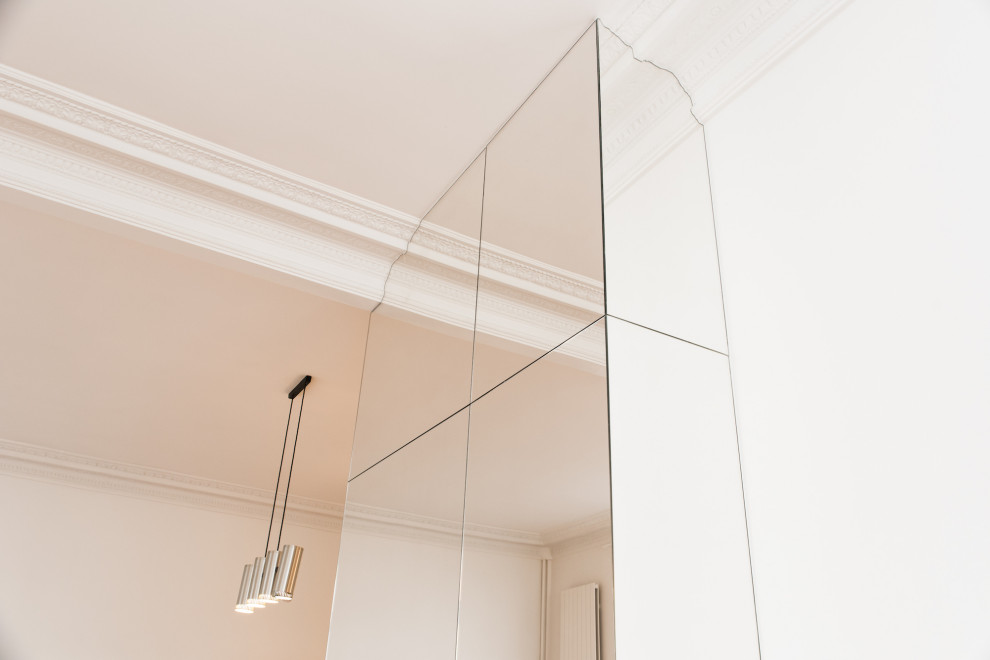 Design ideas for a large contemporary gender-neutral built-in wardrobe in Paris with glass-front cabinets.