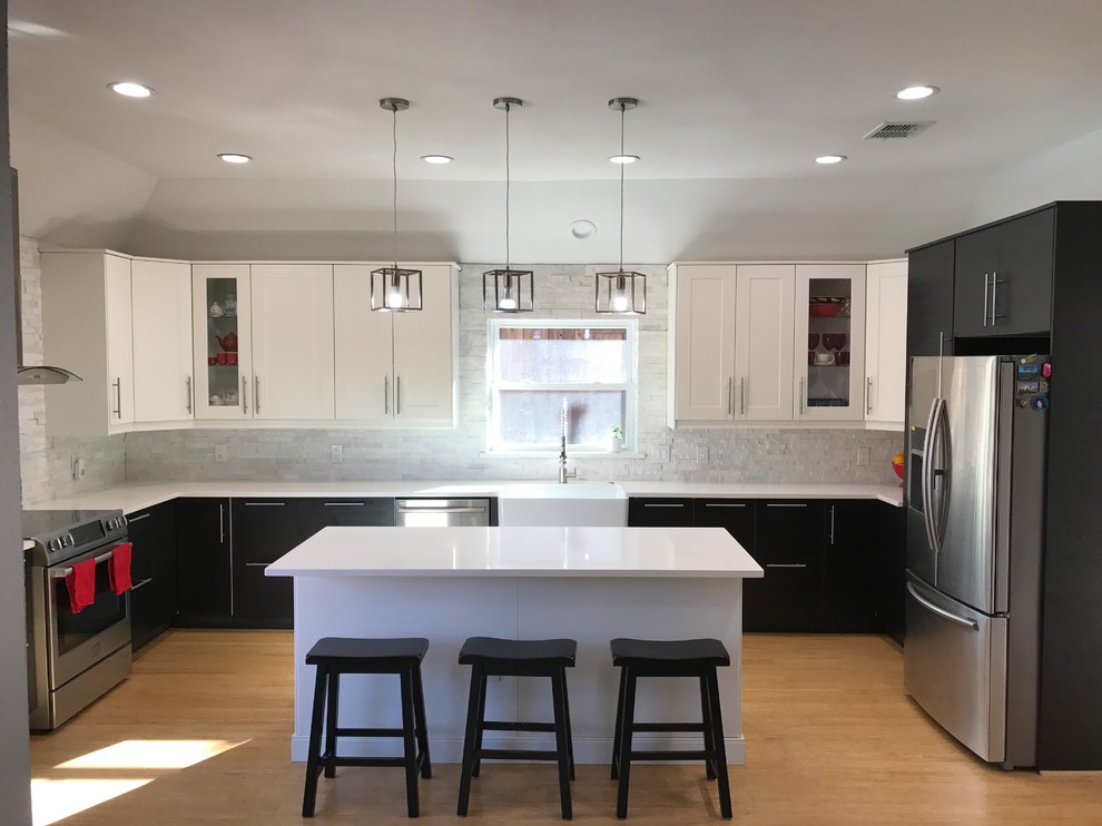 Inspiration for a large contemporary u-shaped eat-in kitchen in Dallas with a farmhouse sink, shaker cabinets, white cabinets, solid surface benchtops, grey splashback, stone tile splashback, stainless steel appliances, light hardwood floors, with island and brown floor.