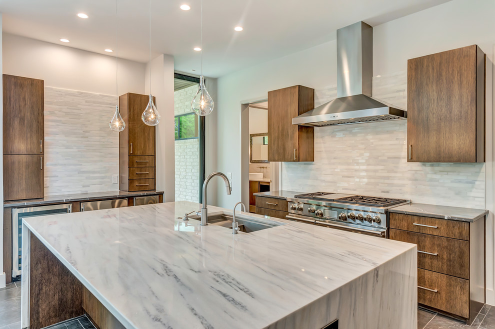 This is an example of a modern eat-in kitchen in Dallas with an undermount sink, flat-panel cabinets, medium wood cabinets, quartz benchtops, white splashback, marble splashback, stainless steel appliances, porcelain floors, with island and grey floor.