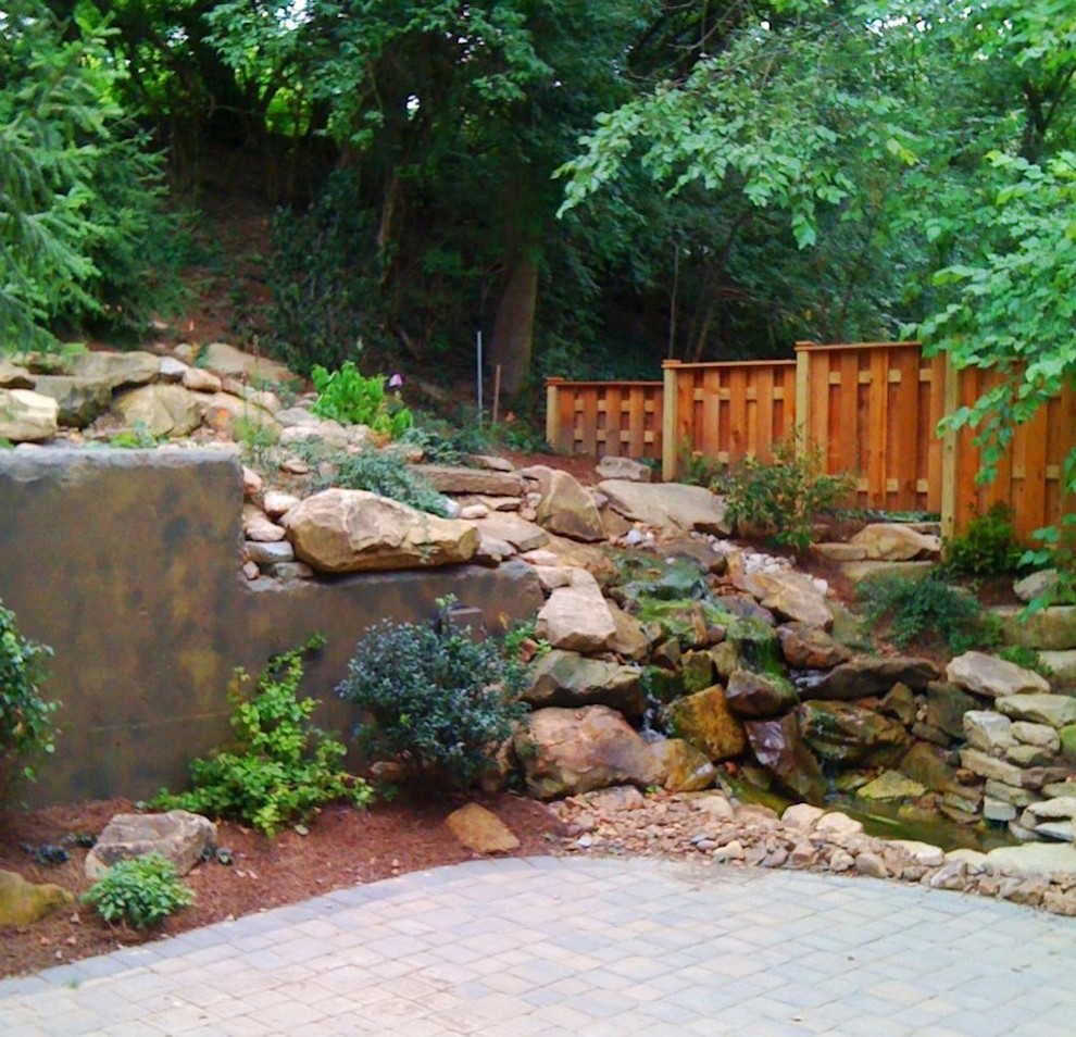 This is an example of a mid-sized transitional full sun backyard stone landscaping in Cincinnati for spring.