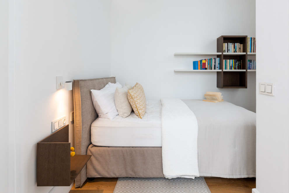 Ejemplo de habitación de invitados contemporánea de tamaño medio con paredes blancas, suelo de madera en tonos medios y suelo marrón